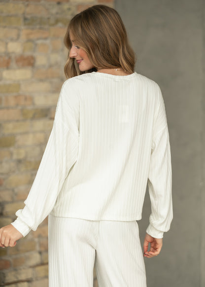 Back of bone white ribbed long sleeve top with dropped shoulders, styled with matching ribbed pants.
