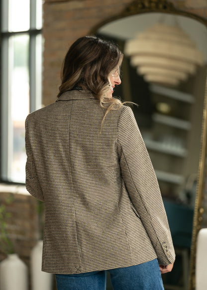 Back of tan and black check blazer showing tailored seams, long sleeves, and loose silhouette.