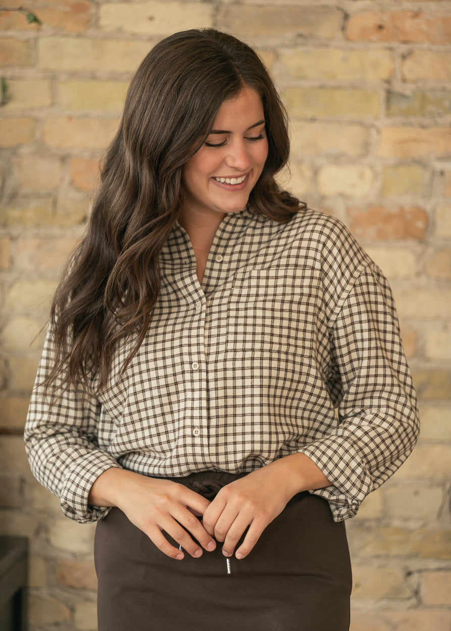 Z Supply River plaid button-up top in cream and chocolate with chest pocket, styled with a brown midi skirt.