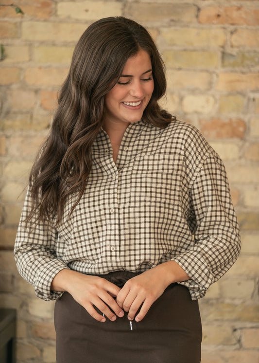 Z Supply River plaid button-up top in cream and chocolate with chest pocket, styled with a brown midi skirt.