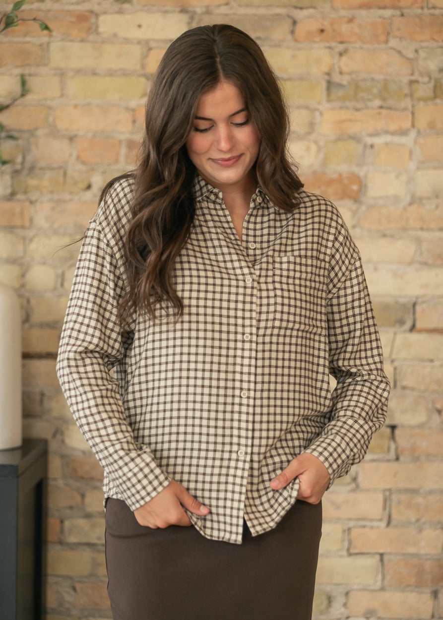 Front view of cream and chocolate plaid button-up top showing loose fit, hip length, and chest pocket.