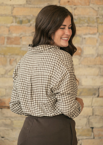 Close-up back view of cream and chocolate plaid button-up top showing the plaid pattern and loose drape.