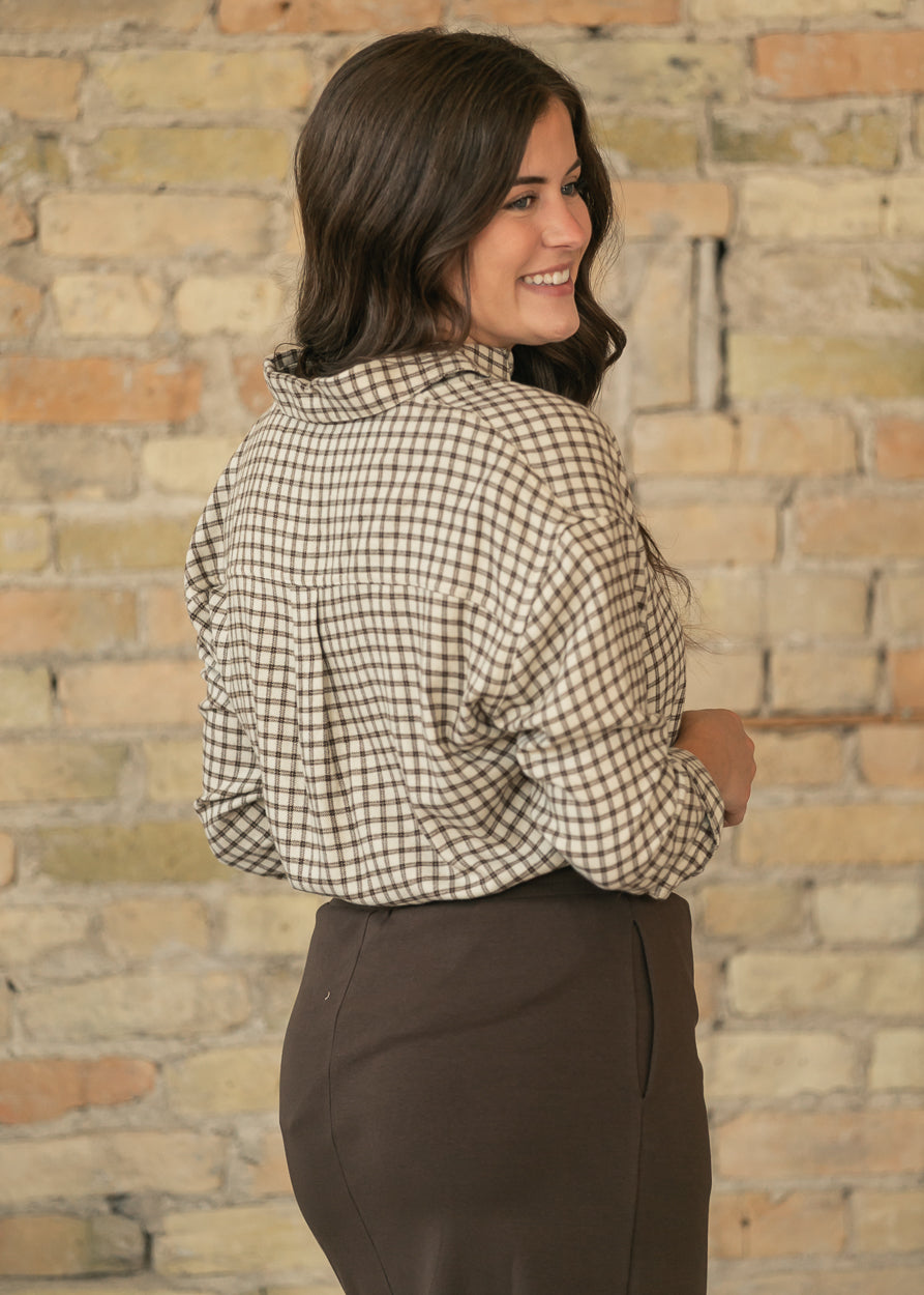 Back of cream and chocolate plaid button-up top showing loose fit, dropped shoulders, and back yoke detail.