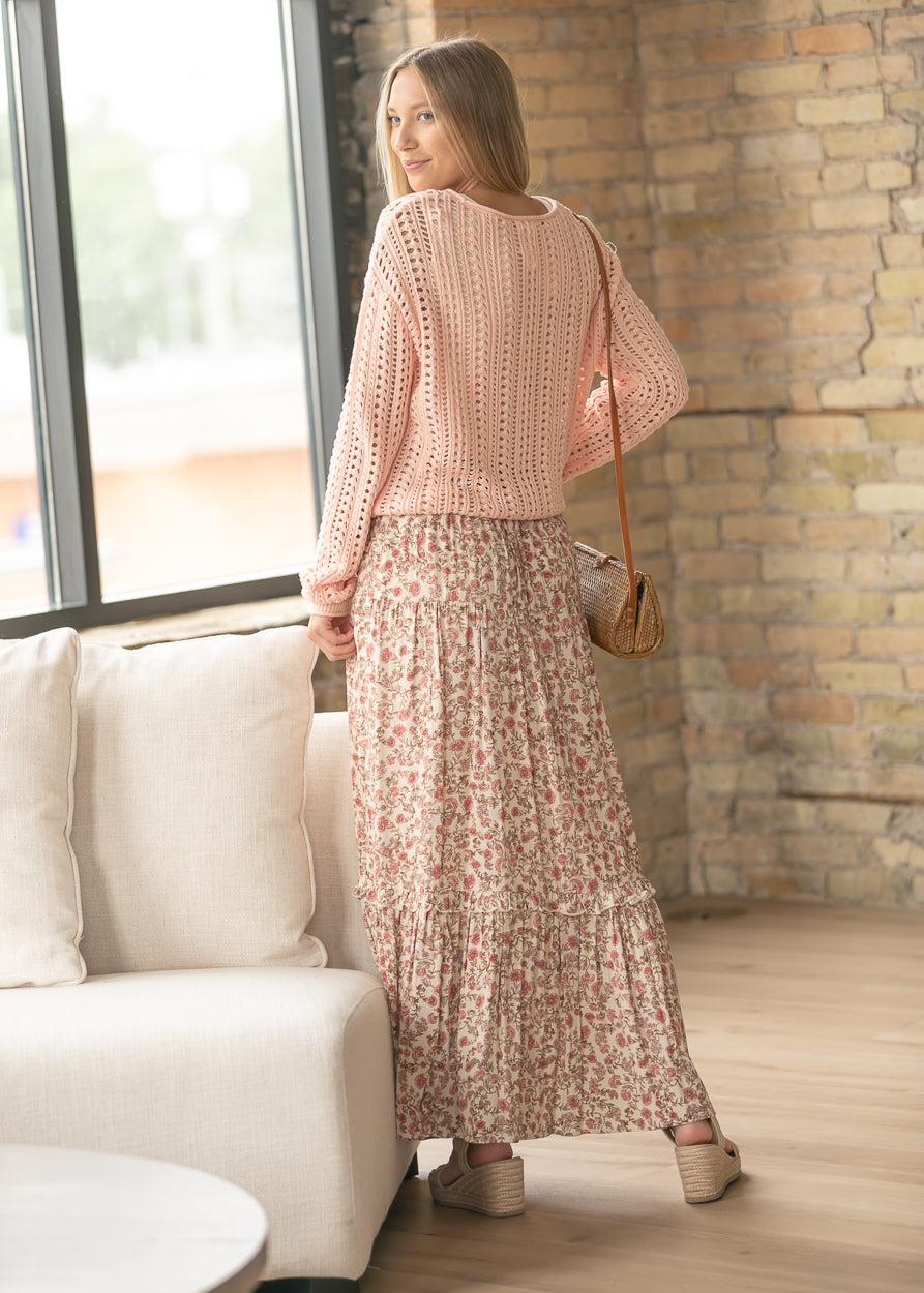 Floral maxi skirt styled with a blush knit sweater and woven crossbody bag.