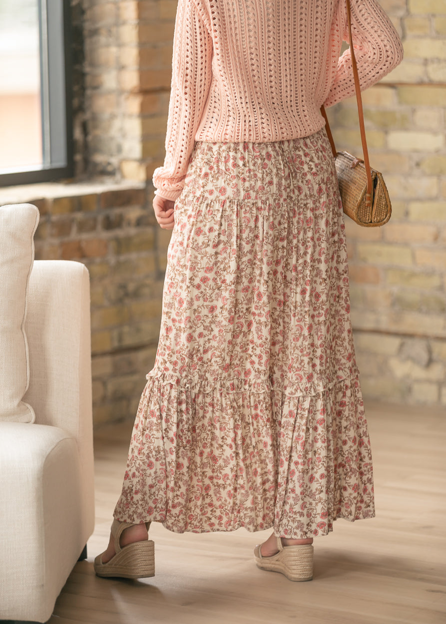 Floral maxi skirt styled with a blush knit sweater and woven crossbody bag.