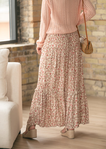 Floral maxi skirt styled with a blush knit sweater and woven crossbody bag.