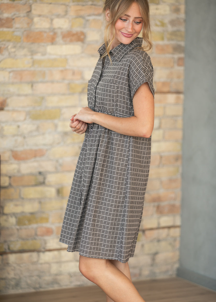 Side view of brown plaid short sleeve midi dress showing the relaxed drape and collared neckline.
