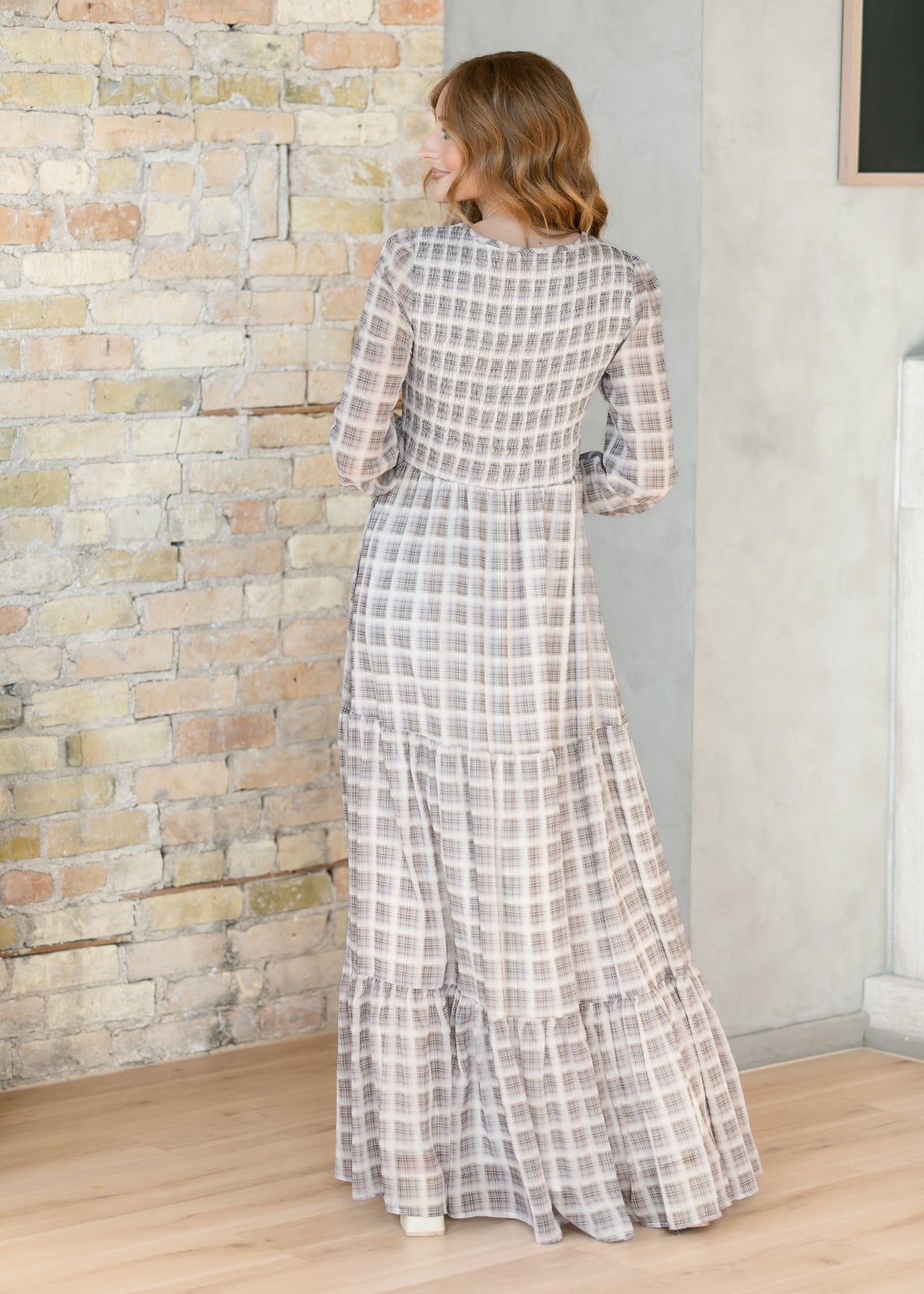 Back of the taupe plaid maxi dress showing the smocked bodice and tiered skirt.