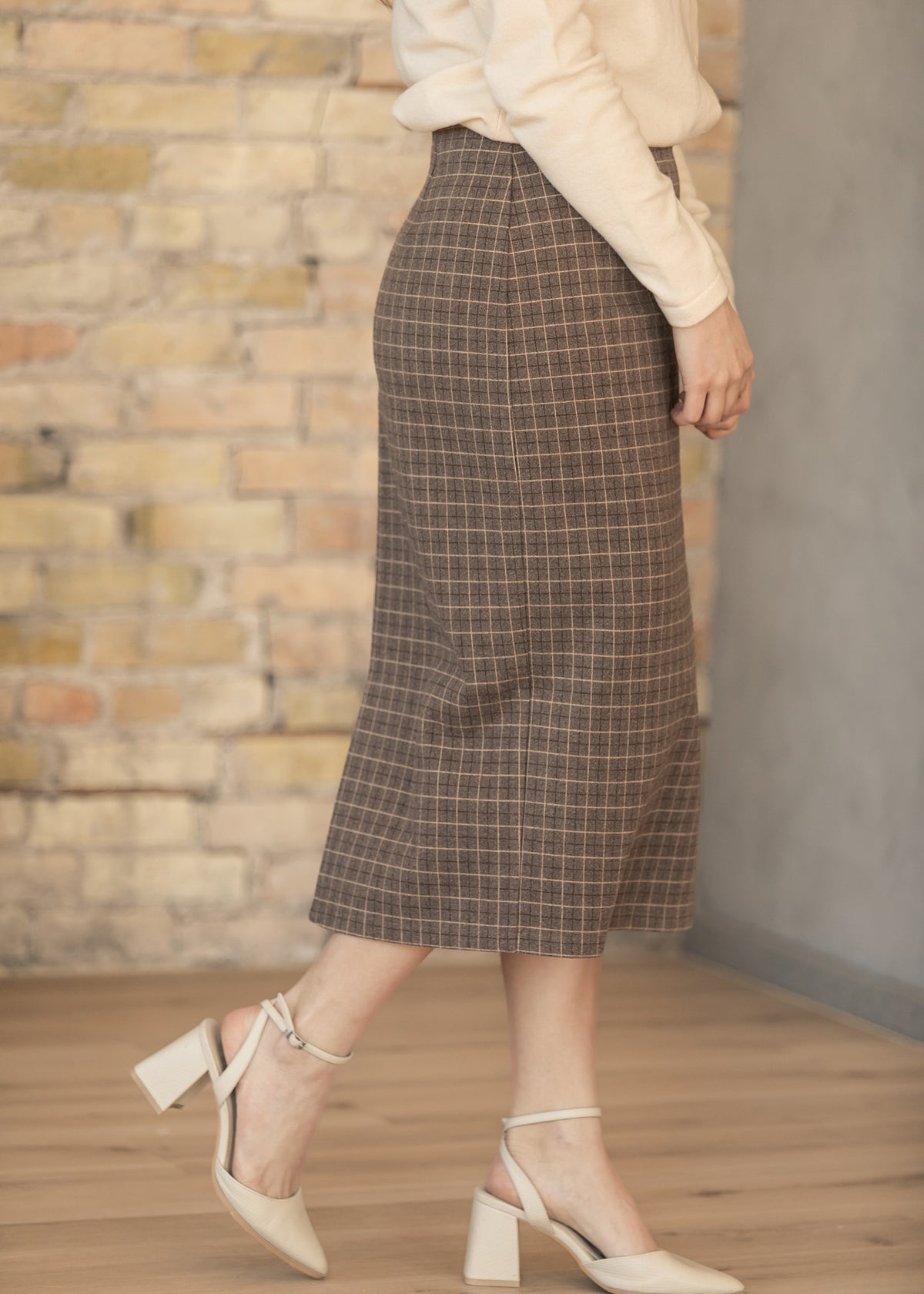 Side profile of brown plaid midi pencil skirt with classic tailored fit.