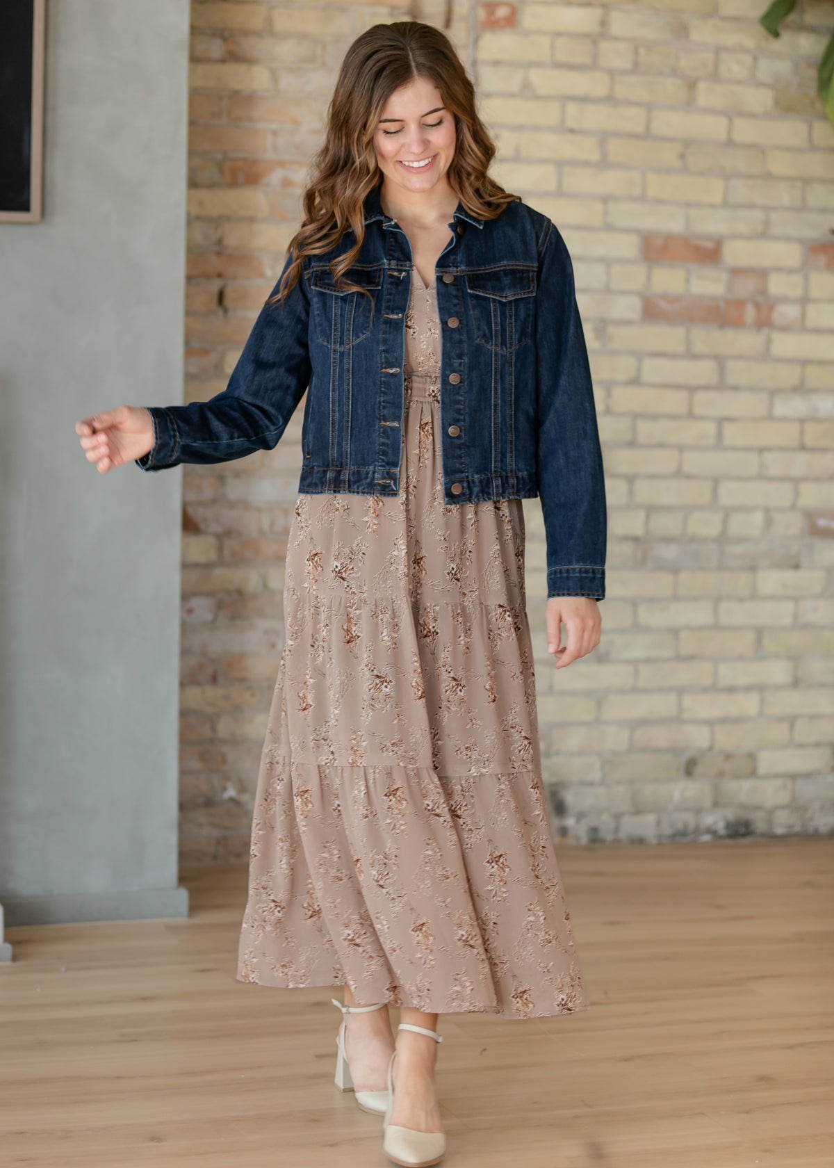 Celia brown floral maxi dress layered with a dark wash denim jacket and neutral heels.