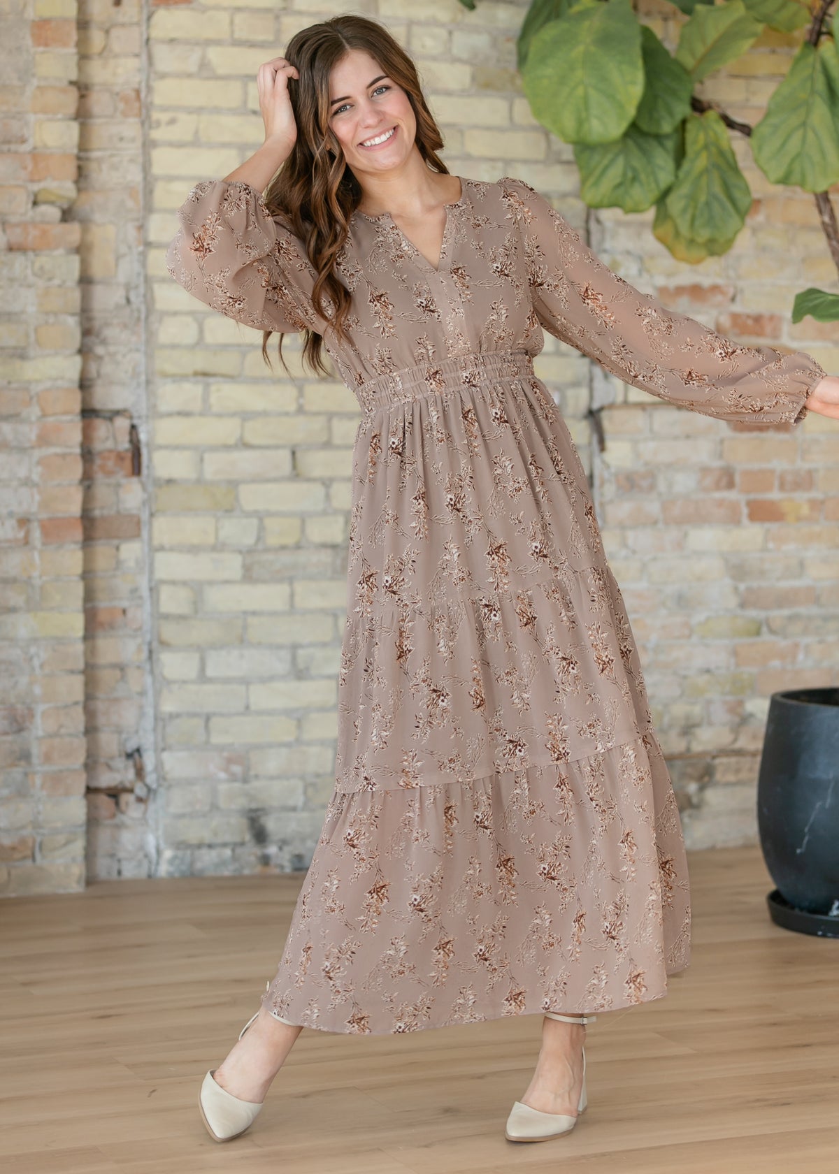Celia brown floral maxi dress with long sleeves and flowing skirt shown in motion.