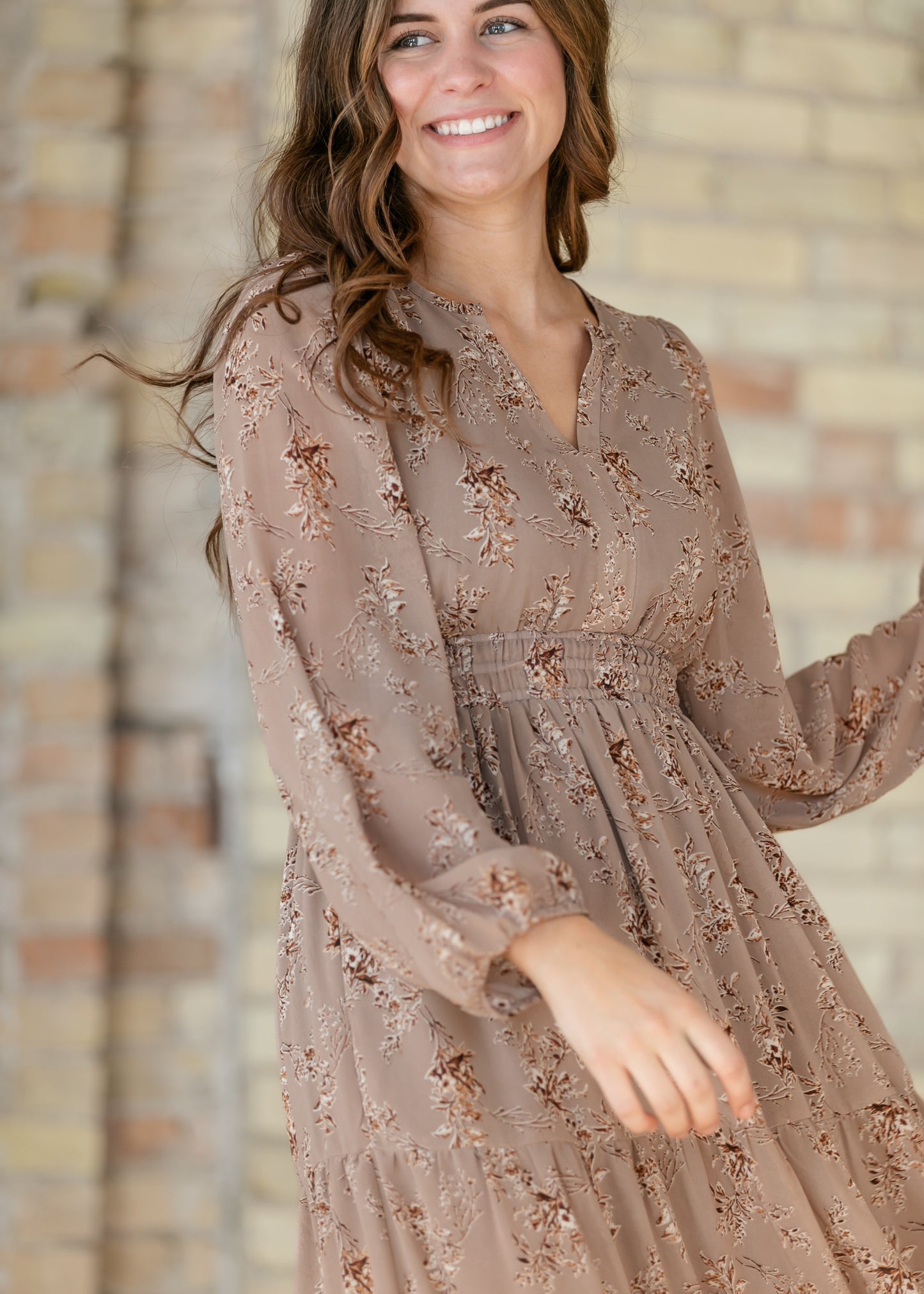 Close-up of brown floral maxi dress showing the V-neck, long sleeves, and smocked waist.