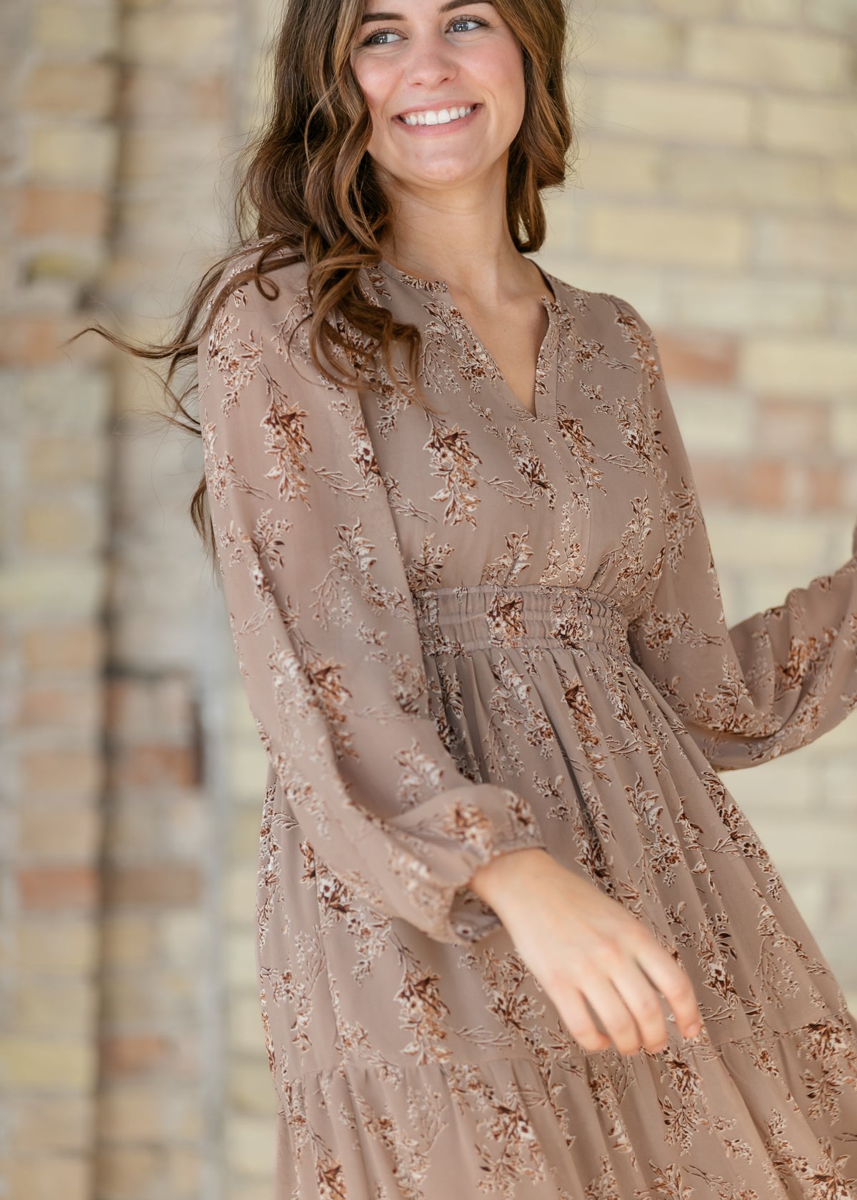 Close-up of brown floral maxi dress showing the V-neck, long sleeves, and smocked waist.