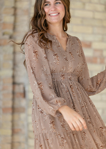Close-up of brown floral maxi dress showing the V-neck, long sleeves, and smocked waist.