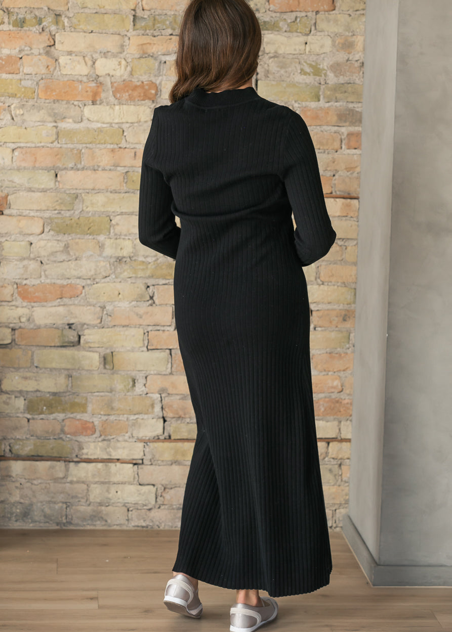 Back of the Ashdon black ribbed maxi dress showing long sleeves, a high neckline, and an ankle-length hem.
