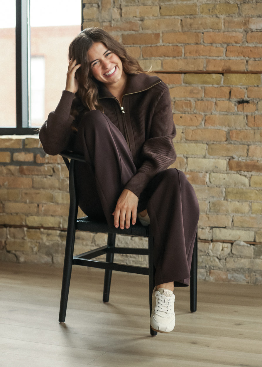 Coffee Bean Varley wide-leg pant styled with a coordinating brown knit jacket and sneakers.