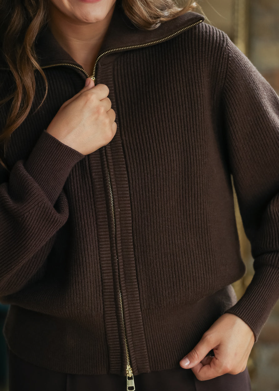 Close-up of functional zipper on brown ribbed knit jacket