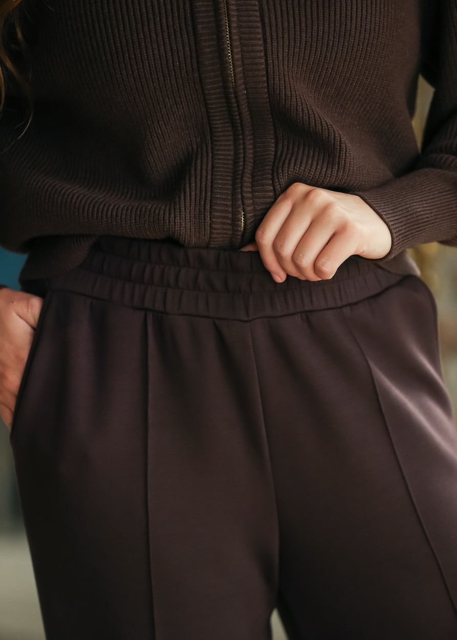 Close-up of Coffee Bean wide-leg pants showing the elastic waistband and smooth stretch fabric.