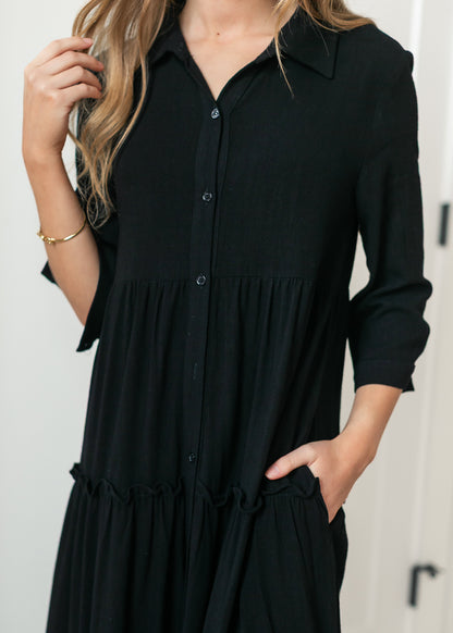 Close-up of black Elsie midi dress showing the neckline and button front detail.