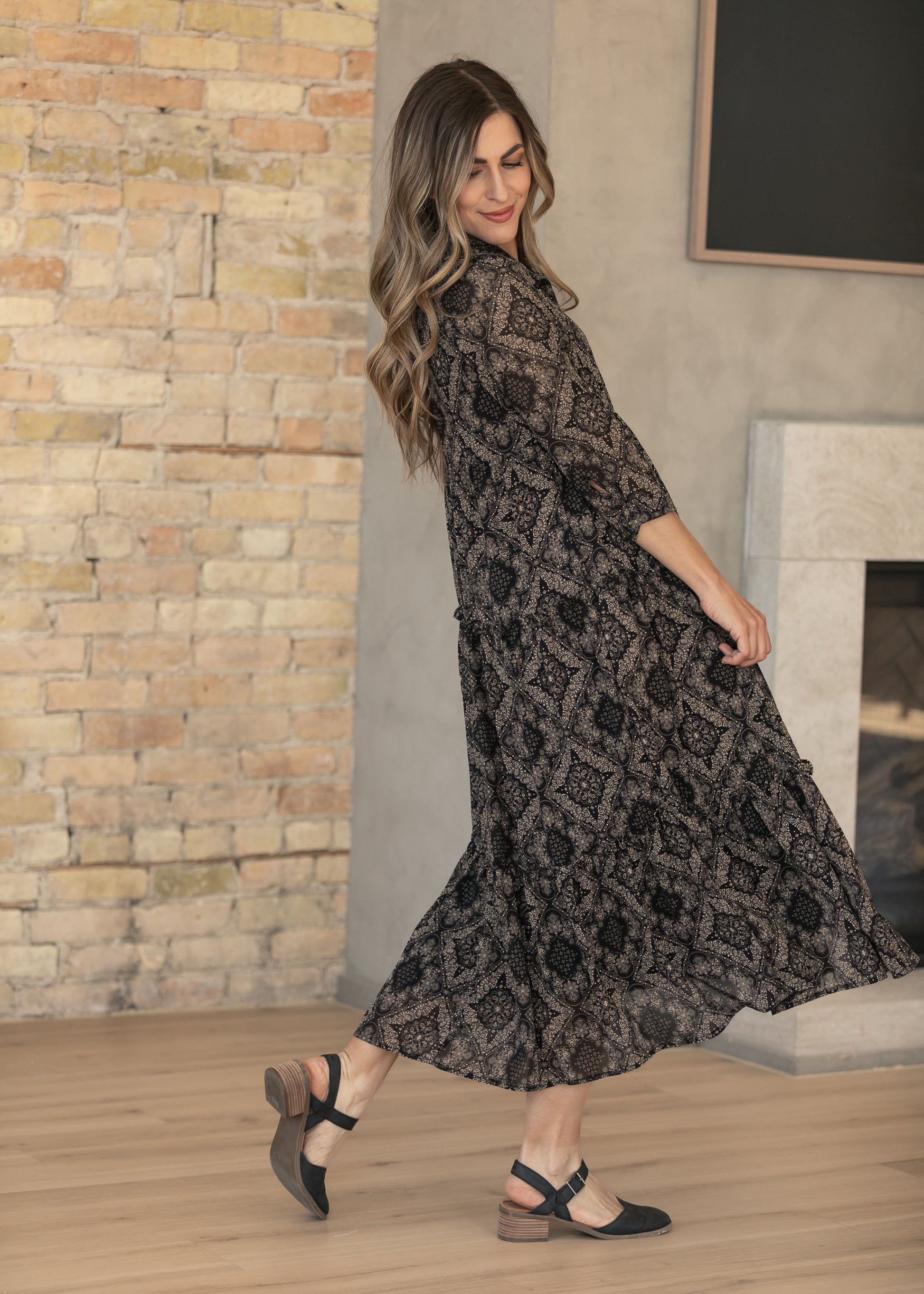 Side view of black and cream paisley midi dress with half sleeves and calf-length hem.