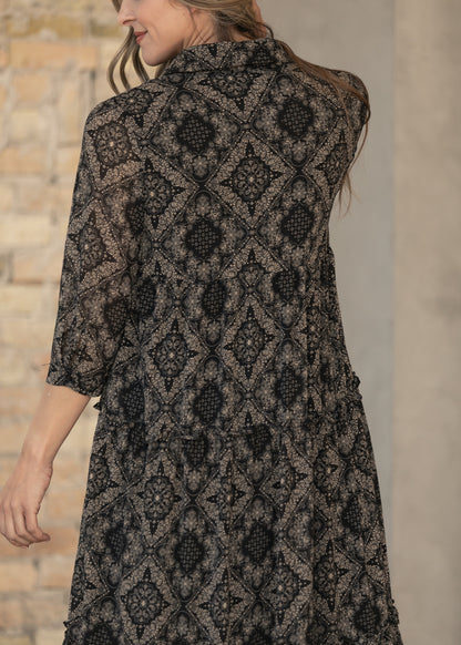 Close-up of paisley midi dress showing the button front and gathered tier detail.