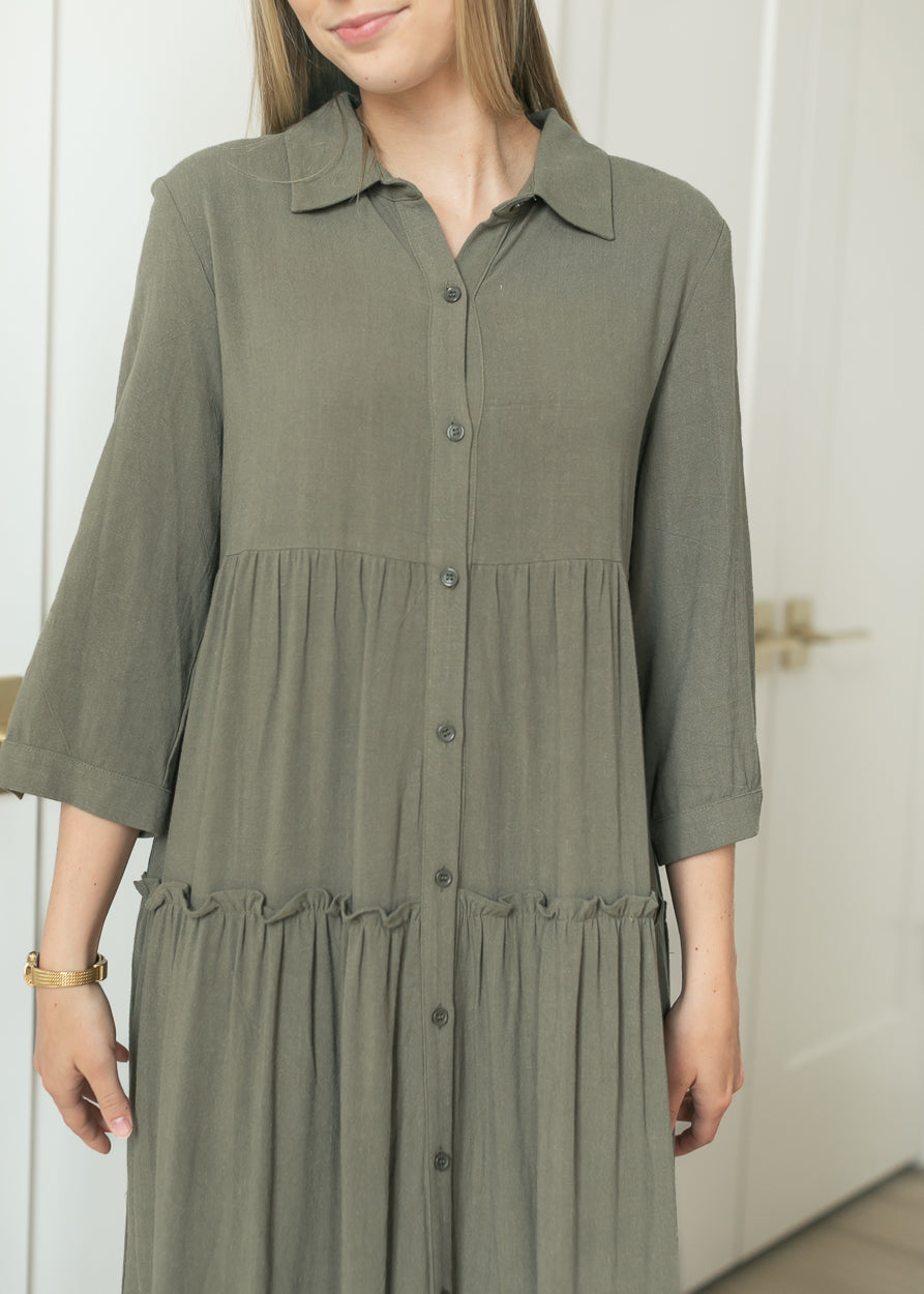 Olive Elsie dress showing the V-neck, button front, and tiered waist detail.