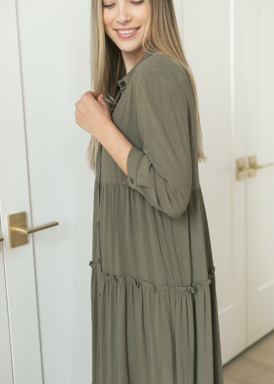 Side view of olive midi dress showing the half sleeves and tiered A-line shape.