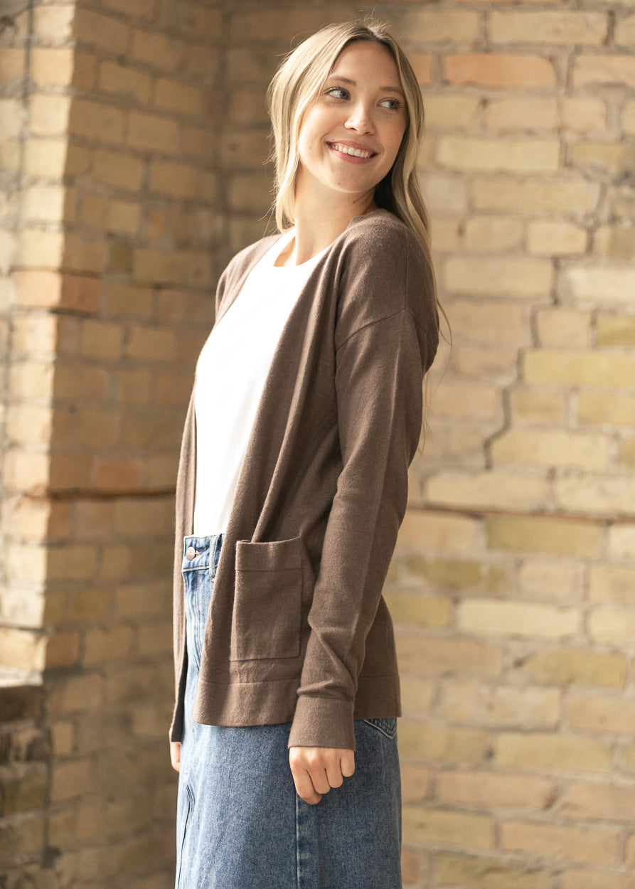 Side view of the coffee cardigan worn over a cream tee and denim skirt.