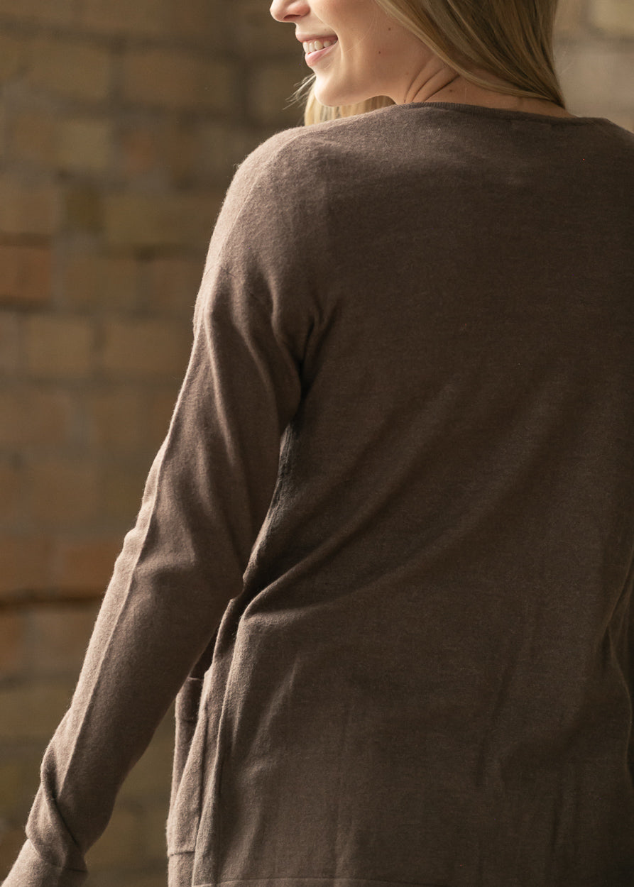 Back view of the coffee short cardigan showing the relaxed hem and back pocket.