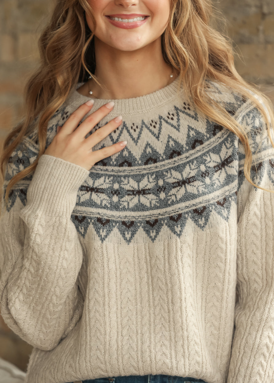 Close-up of cream Fair Isle sweater showing blue knit pattern and texture