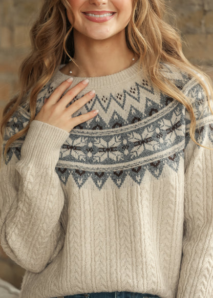 Close-up of cream Fair Isle sweater showing blue knit pattern and texture