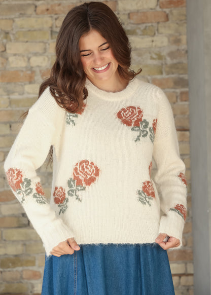 Model wearing a cream floral knit sweater with a blue denim midi skirt, front view