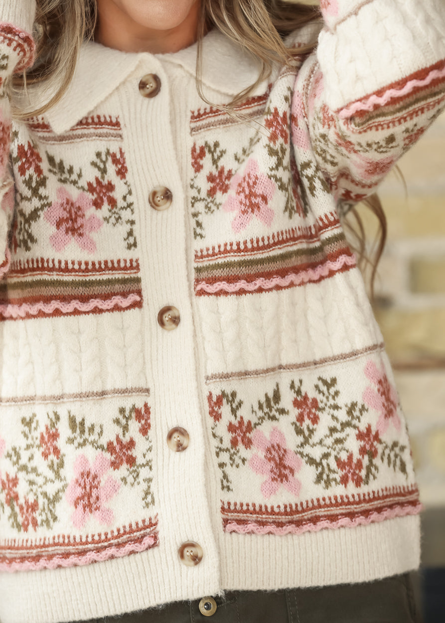 Close-up of cream floral knit cardigan with button-front detail