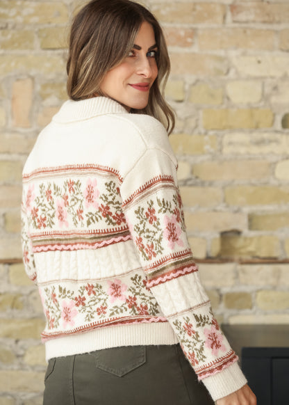 Model wearing a cream floral cardigan with olive skirt, back angled view
