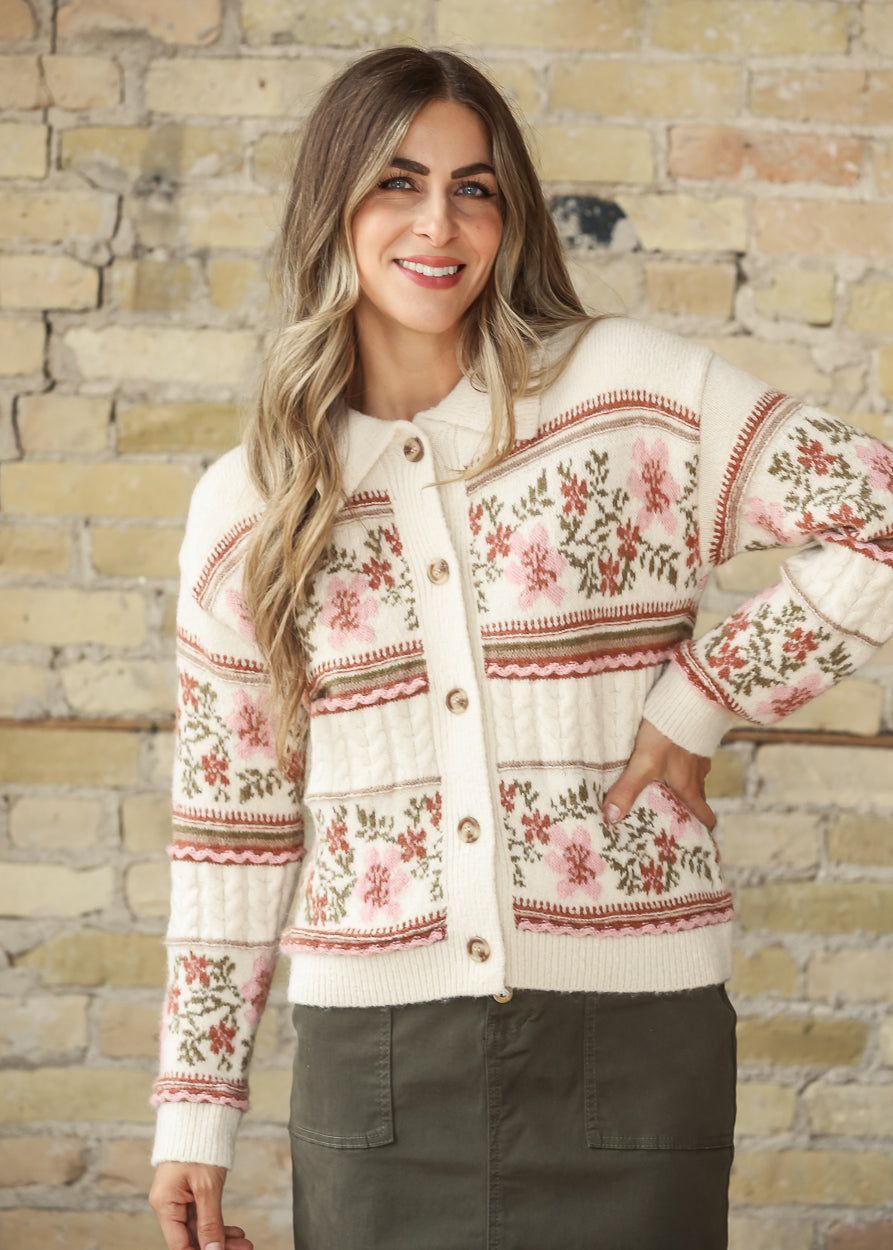 Model wearing a cream floral button-front cardigan with an olive skirt, front view