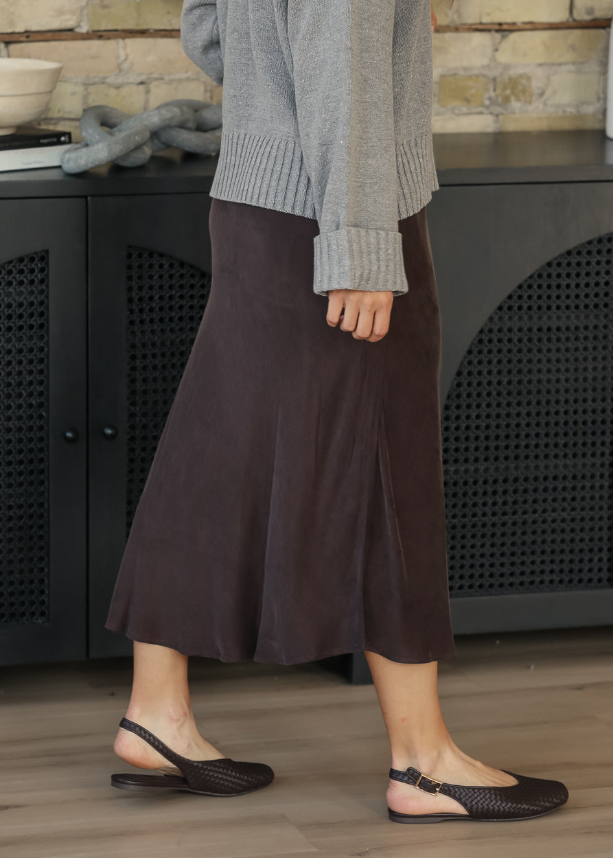 Side view of dark chocolate faux suede midi skirt showing its flowy silhouette