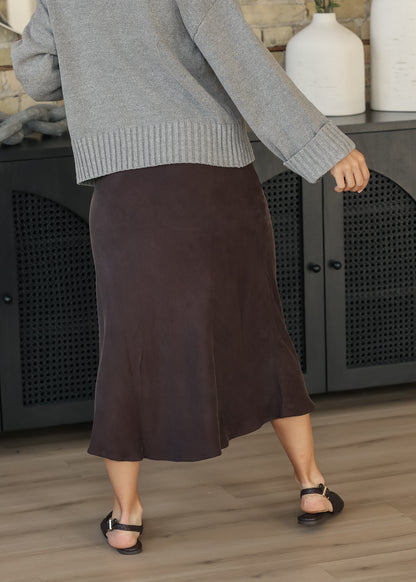 Back angled view of dark chocolate faux suede midi skirt styled with a gray sweater