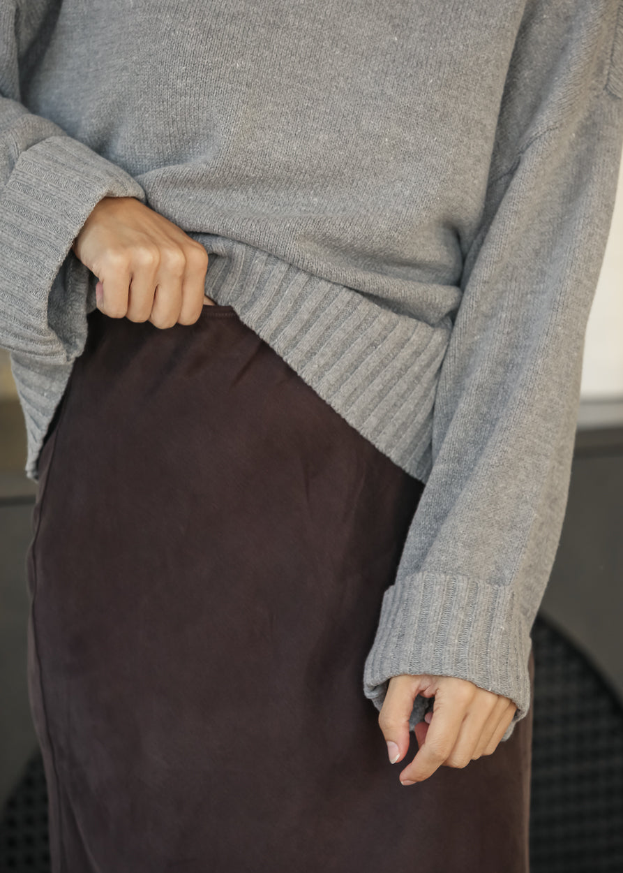 Close-up of dark chocolate faux suede midi skirt showing the soft texture and waistband