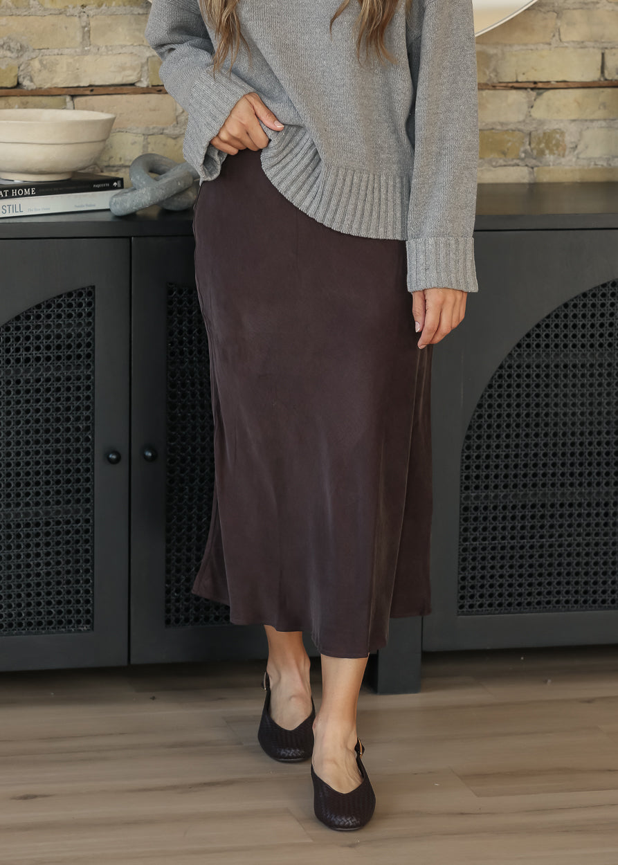 Model wearing a gray sweater with a dark chocolate faux suede midi skirt, front view
