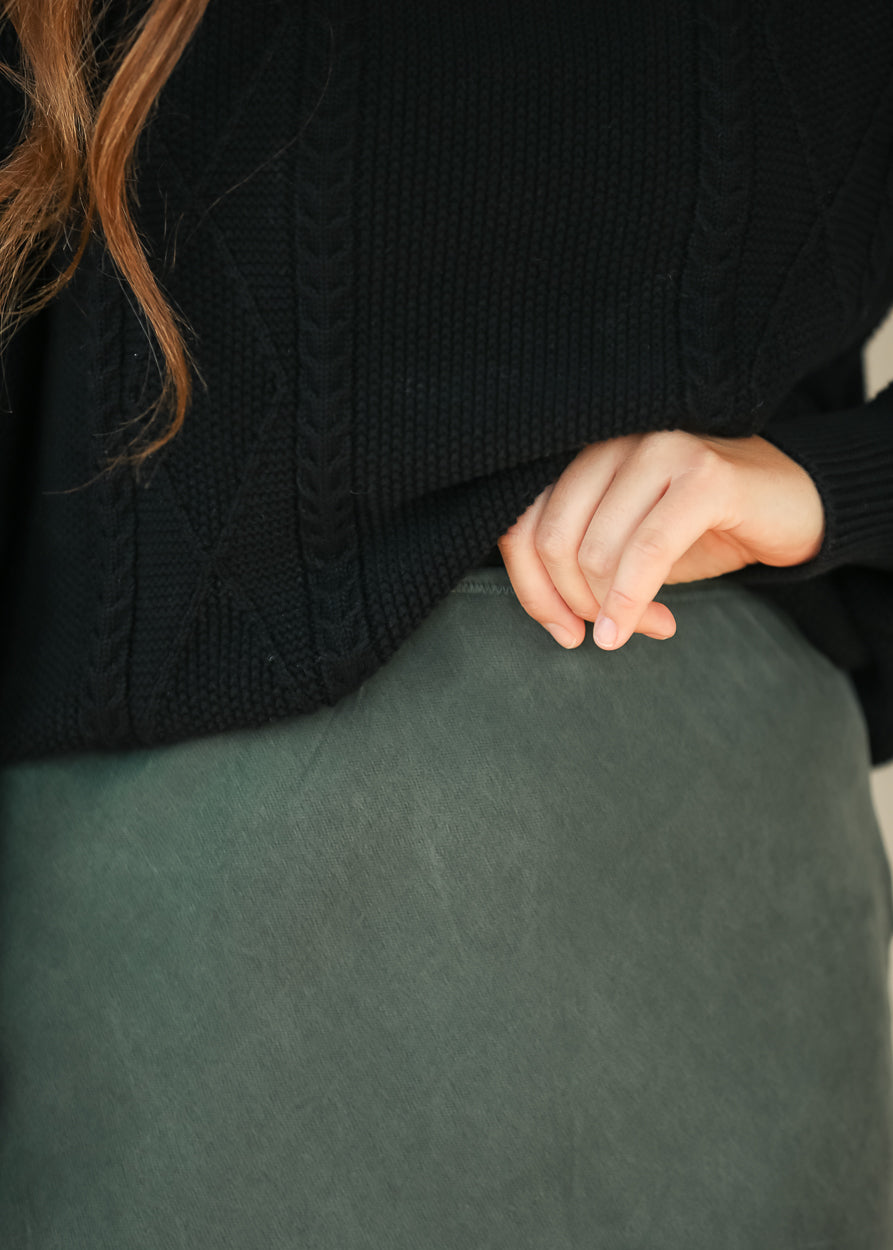 Close-up of emerald faux suede midi skirt showing the soft texture and waistband
