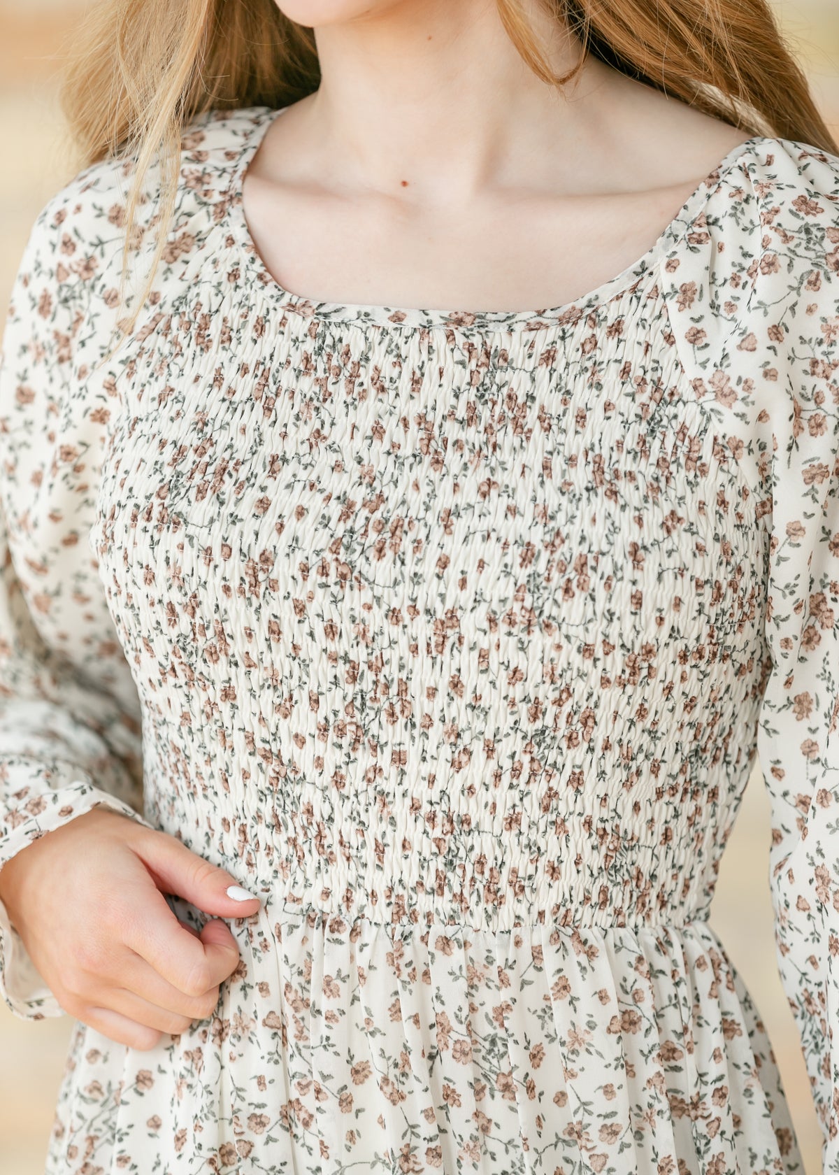 Close-up for the smocked bodice of a floral dress.