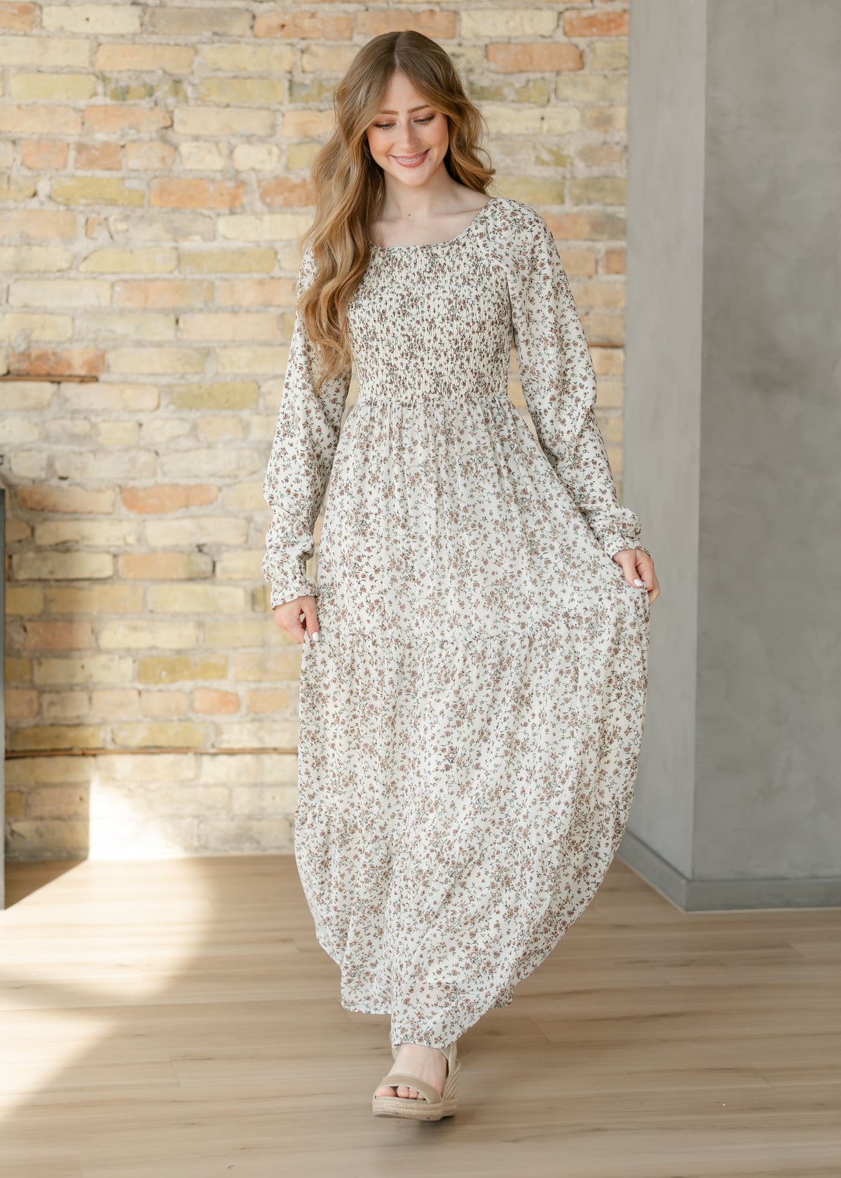 Gia ivory floral maxi dress with smocked bodice, long sleeves, and tiered skirt.