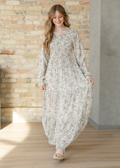 Gia ivory floral maxi dress with smocked bodice, long sleeves, and tiered skirt.