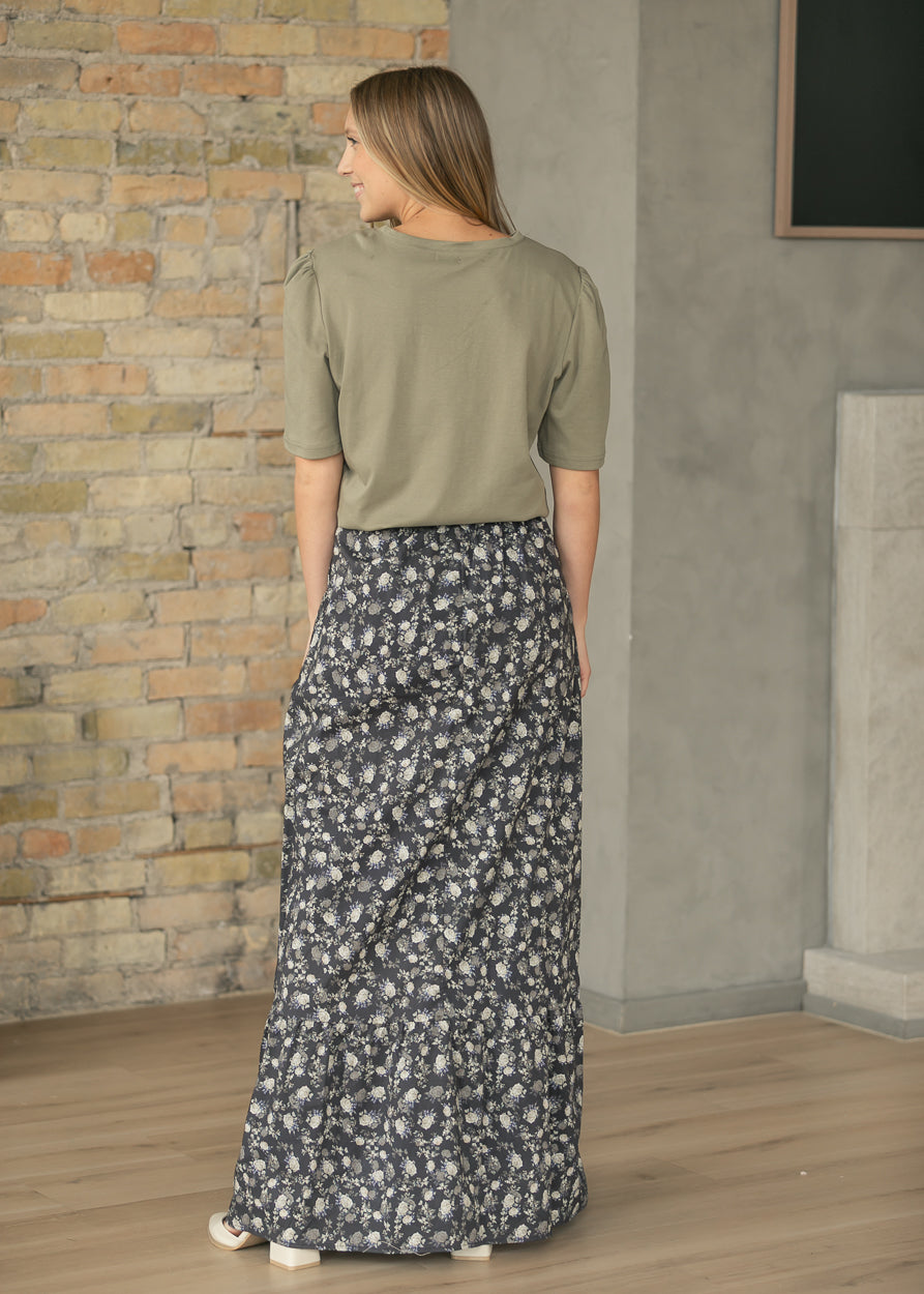 Back view of olive Grace shirt styled with a dark floral maxi skirt.