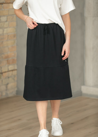 Black Gracie midi sweat skirt with side pocket and drawstring waist, styled with a white tee.