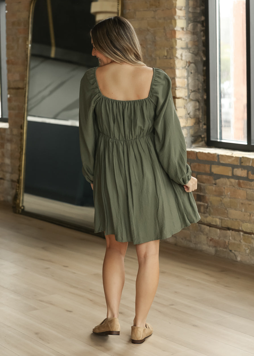 Back of winter sage long sleeve dress showing square back neckline, gathered waist, and softly draped skirt.