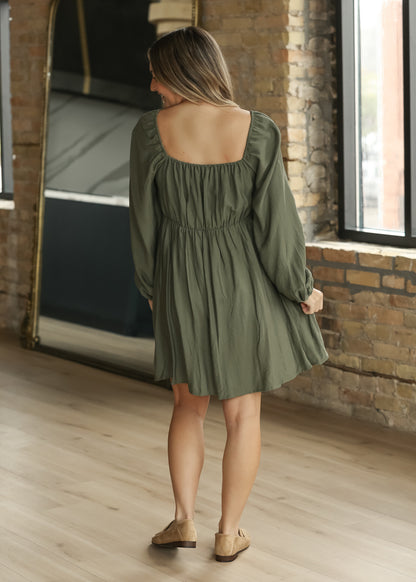 Back of winter sage long sleeve dress showing square back neckline, gathered waist, and softly draped skirt.