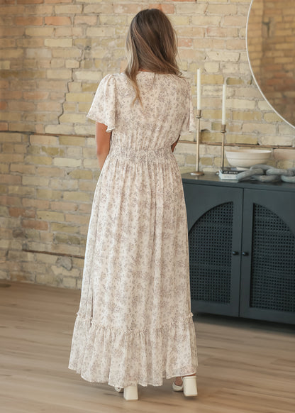 Back of the cream floral maxi dress showing the smocked waist and flutter sleeve detail.