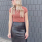 A black midi length faux leather skirt, with small back slit.