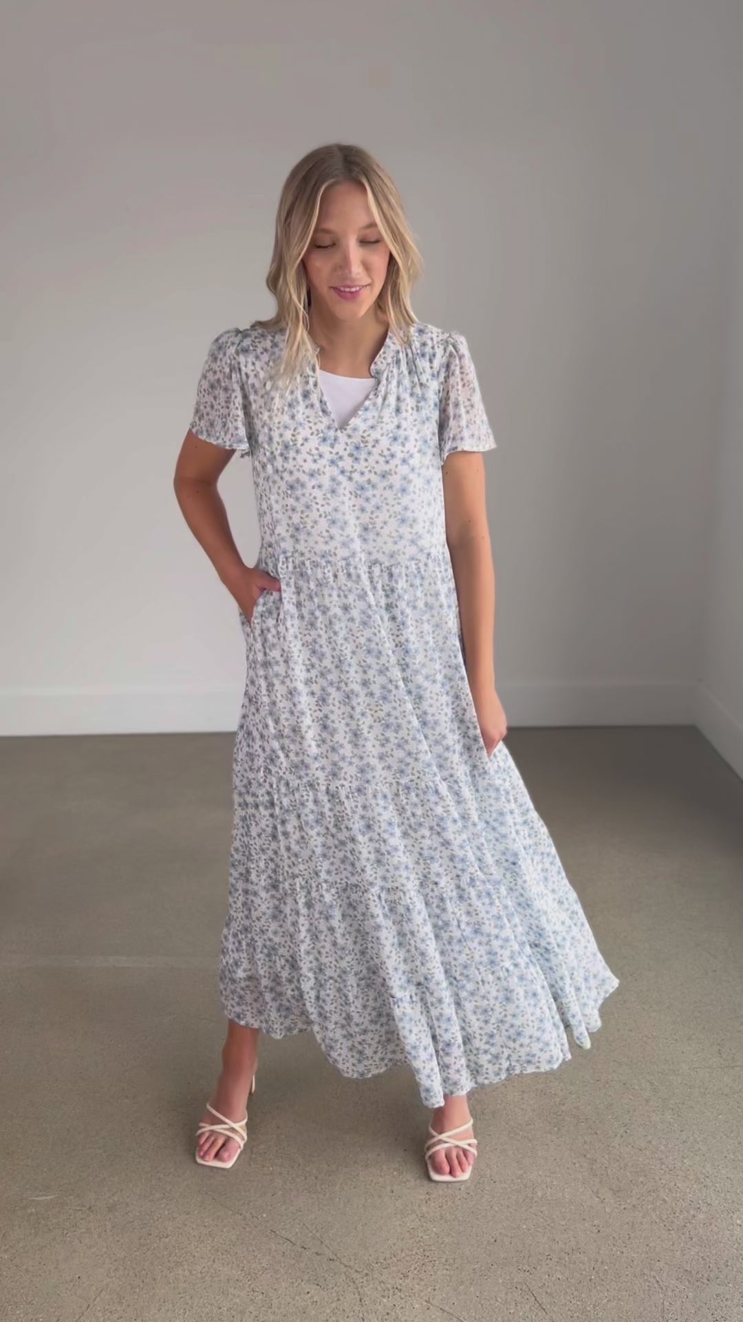 V-neck Blue Floral Maxi Dress is lined, with short sleeves, pockets, and a tiered skirt.